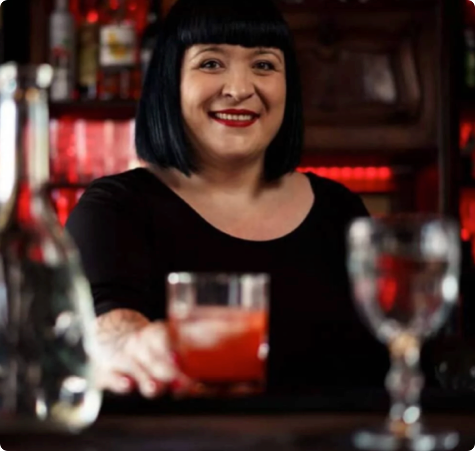 A bartender presenting a cocktail.