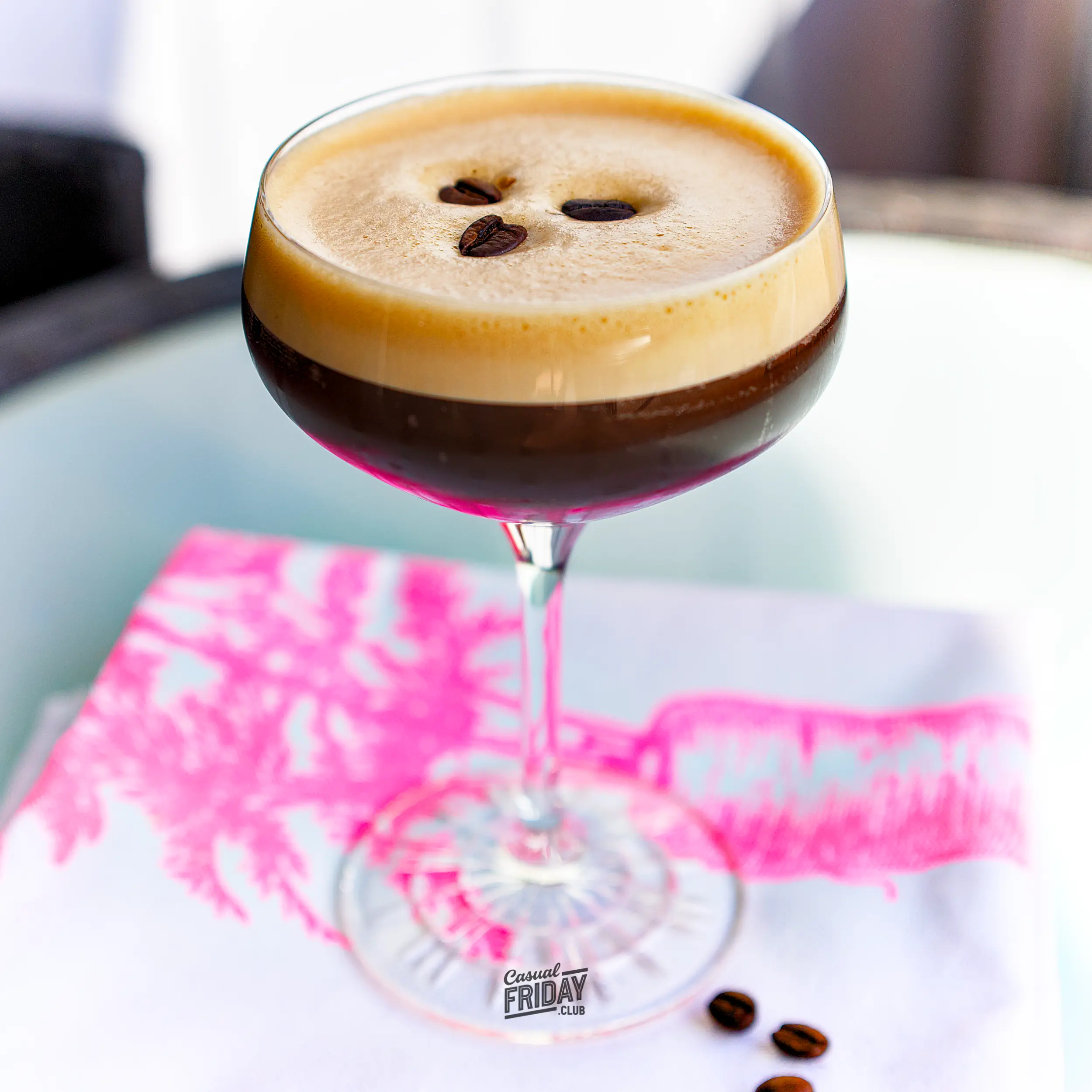 Espresso Martini in a stemmed glass with three coffee beans on the foam.